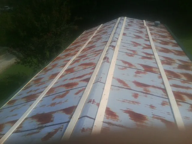 Rusted metal roof panels with new wood purlins before replacement — Storm Damage Roof Repair in Pleasant Hall by Roofing Brothers